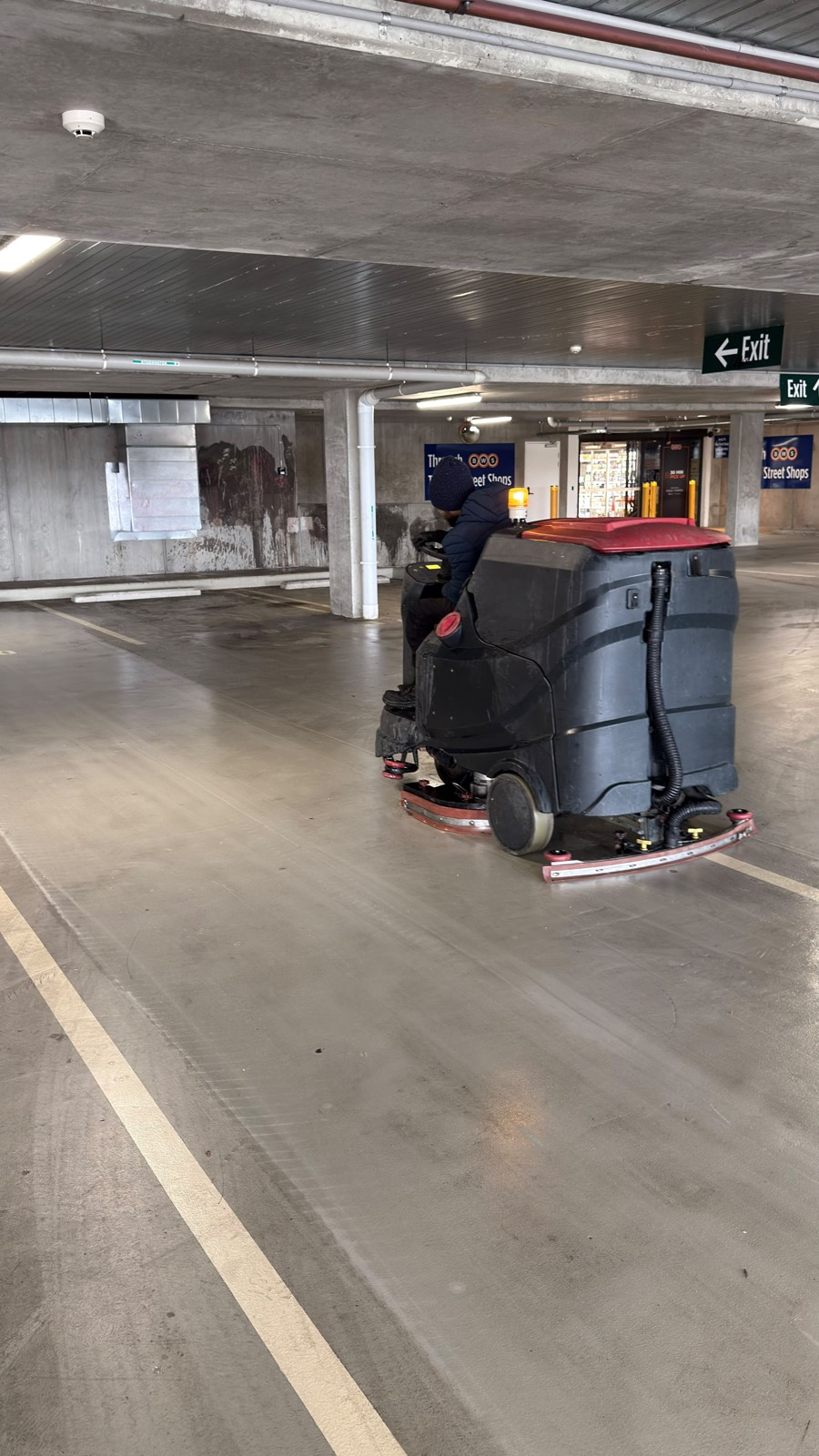 Ride-on scrubber cleaning an underground shopping centre car park